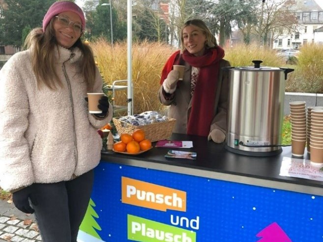 Zwei Mitarbeiterinnen aus dem Team Nachwuchsförderung betreuen den Stand "Punsch und Plausch" an einer Universität