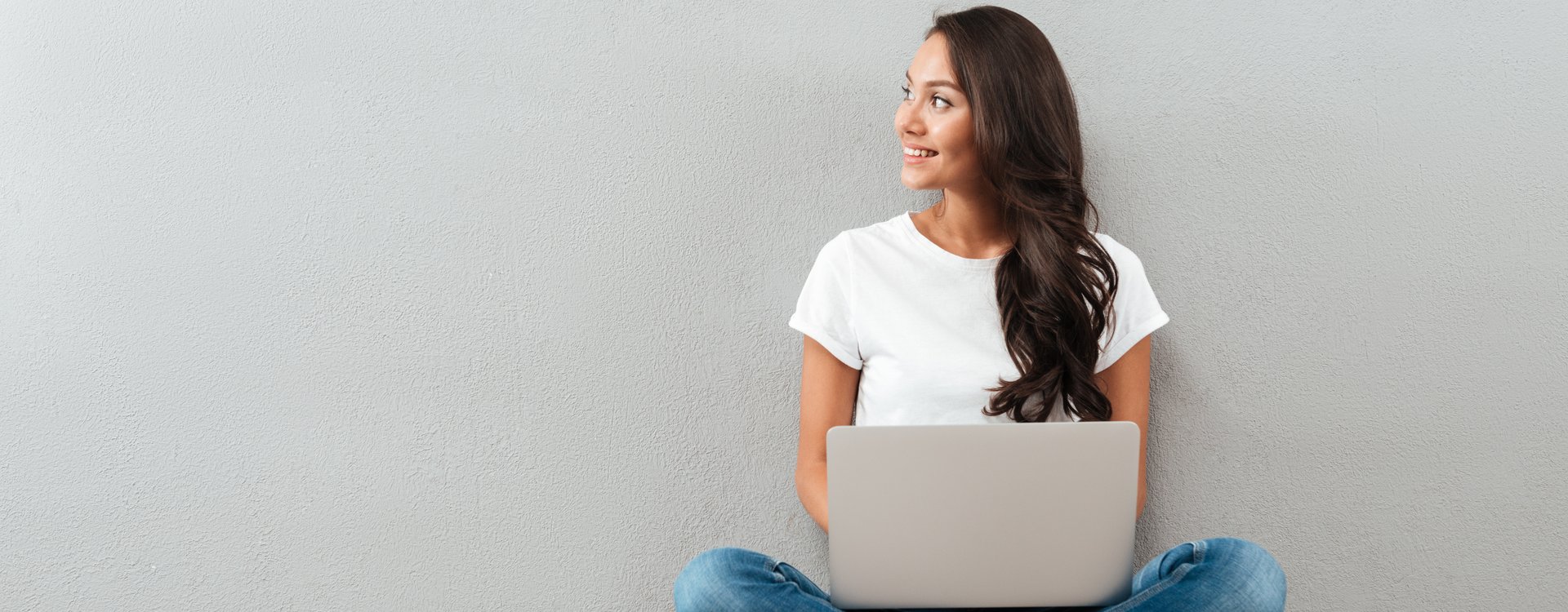 Frau im Schneidersitz mit Laptop