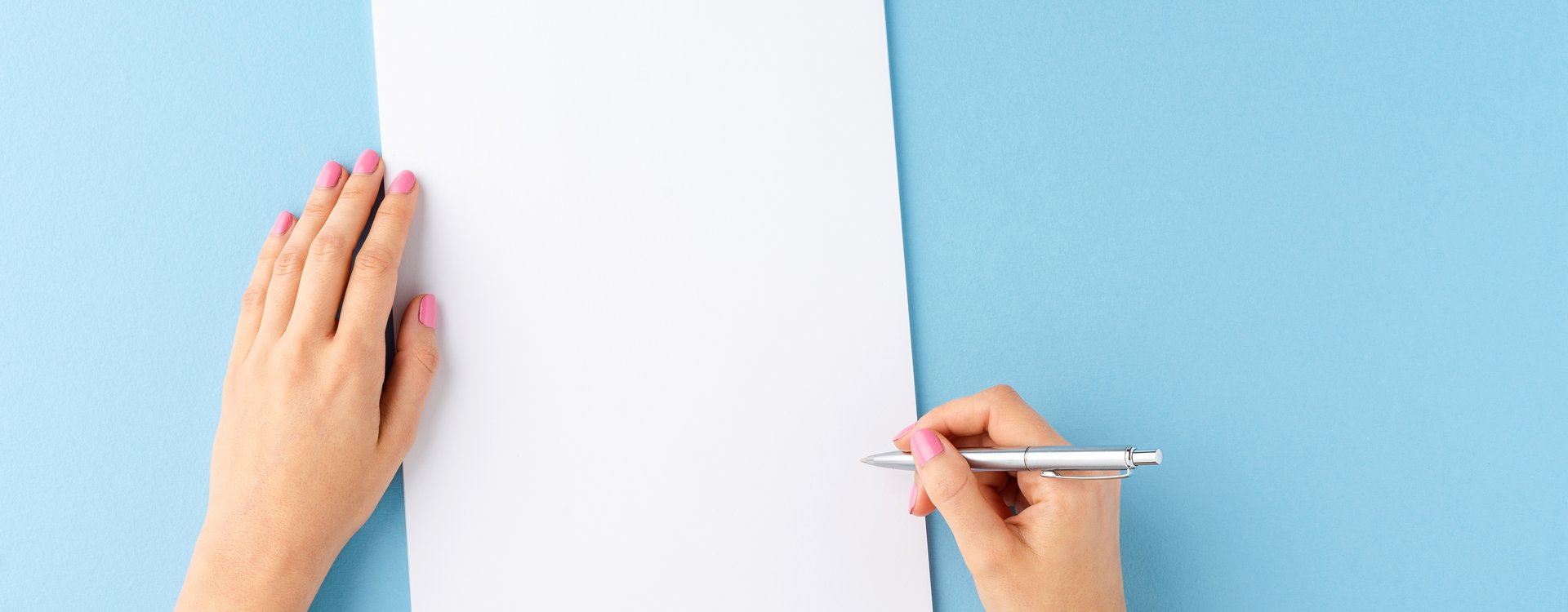 Zwei Hände, eine hält einen Stift die andere ein Blatt Papier